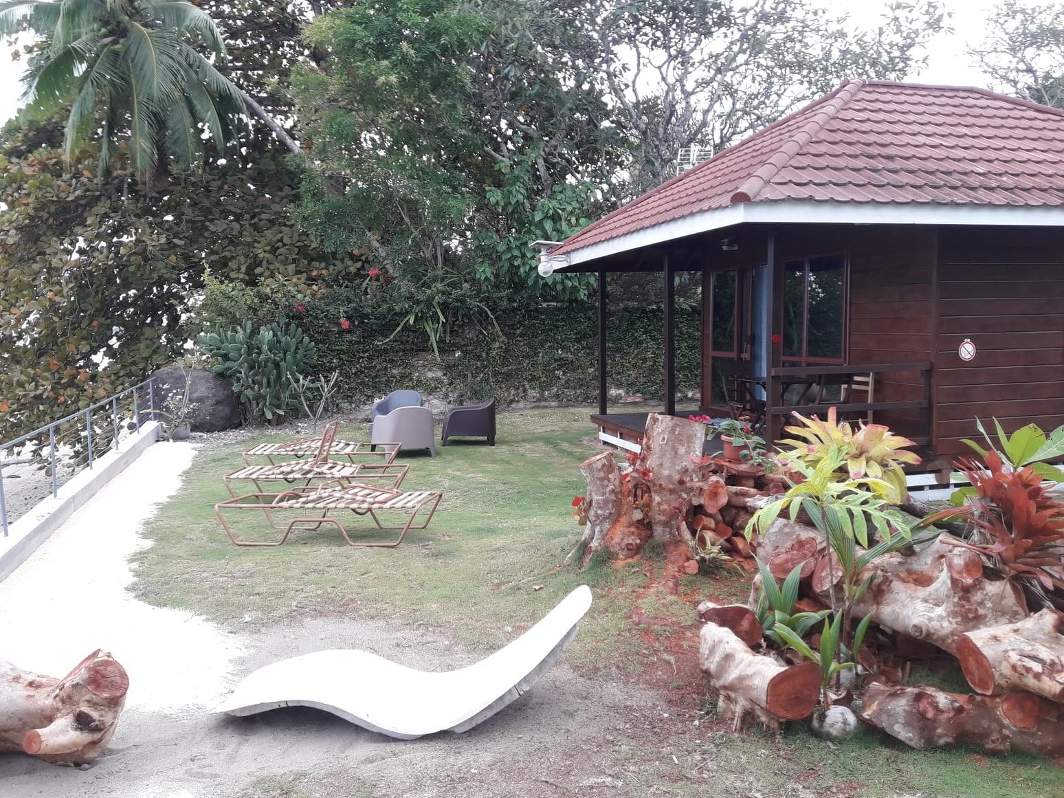 Le jardin du bungalow, souches sculptées et transats