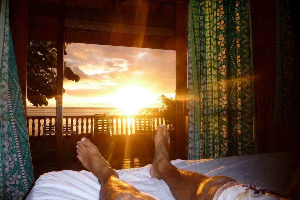 Le coucher de soleil vu depuis le lit, porte ouverte sur la terrasse