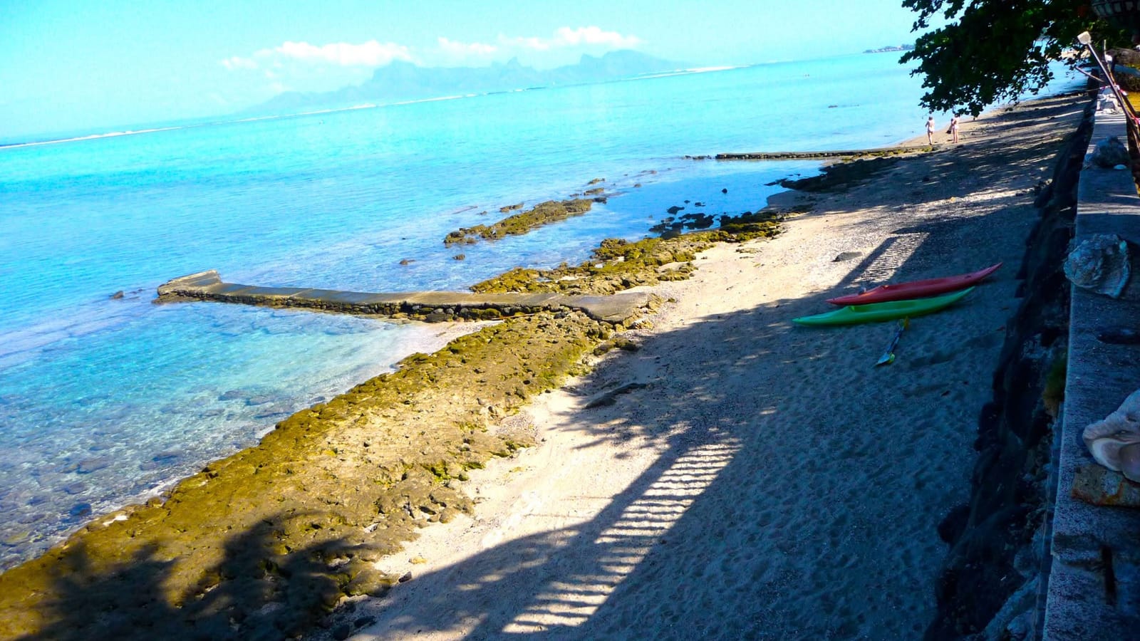 Kayaks posés sur le sable devant le lagon, Moorea à l'horizon