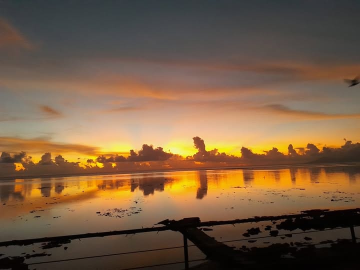 Le récif découvert reflète le ciel orange du soir